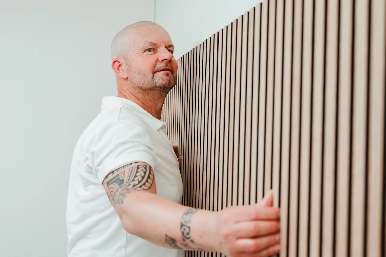 Nico Lange installiert eine Wandpaneele mit hoechster Praezision