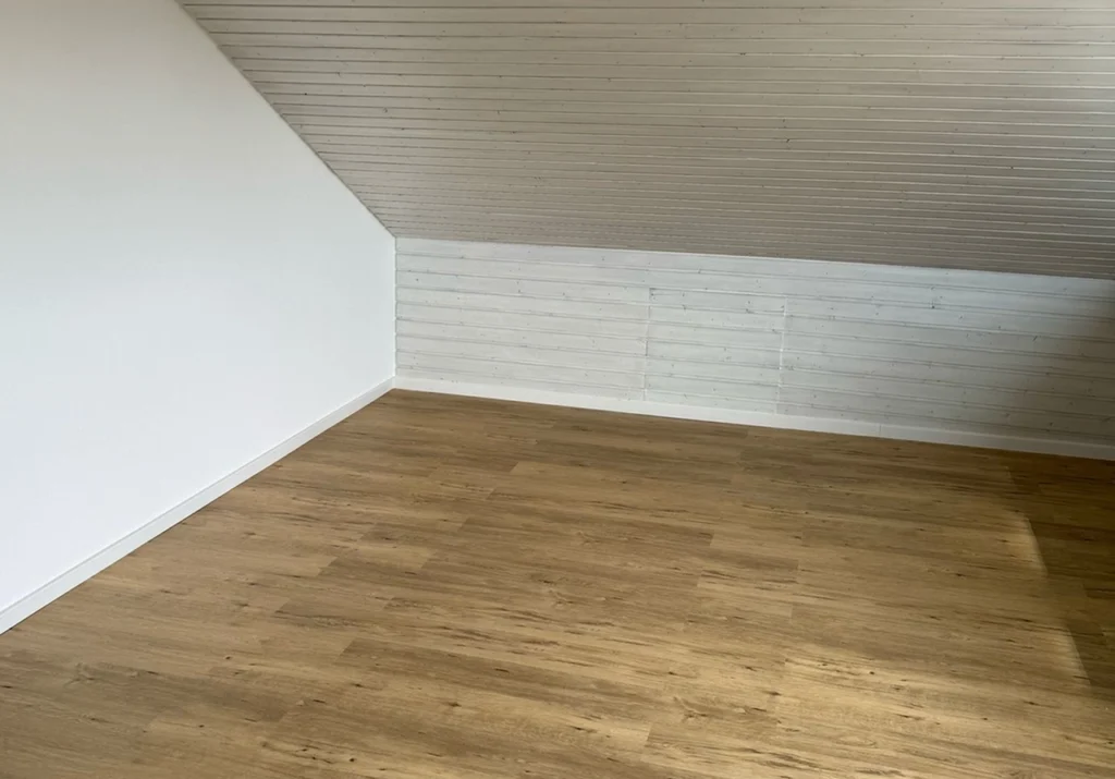 schoener verlegter Laminatboden in Holzoptik mit frisch gestrichener Wand von Malergeschaeft Nico Lange